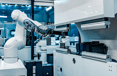 Weißer Industrieroboter in einerm Maschinenbauanlage.