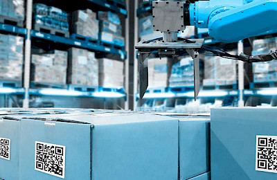 Blue shipping crates in a logistics hall with an industrial robot above them.