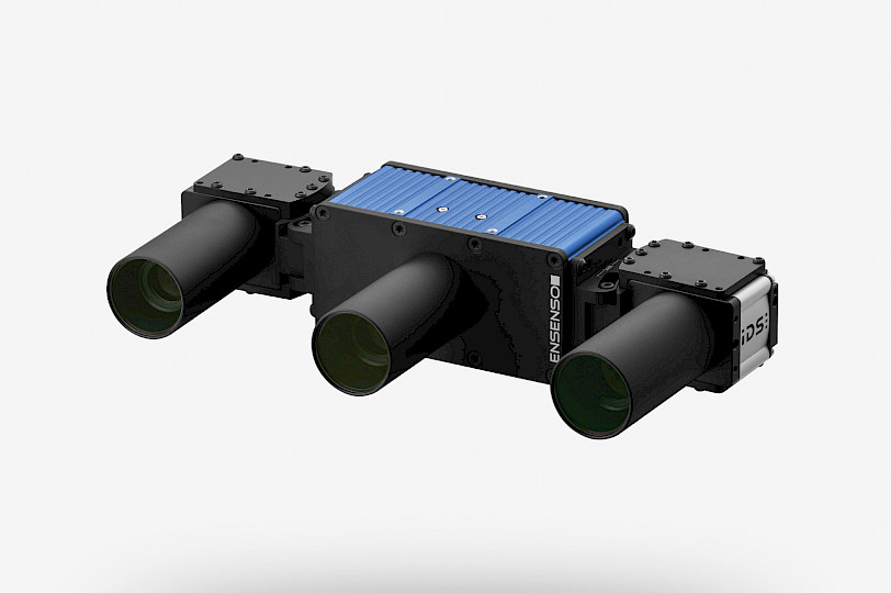 Diagonal front view of the Ensenso X36 3D camera. In the middle, the blue projector module with touch ribs in an aluminum housing and the cameras mounted on the side.